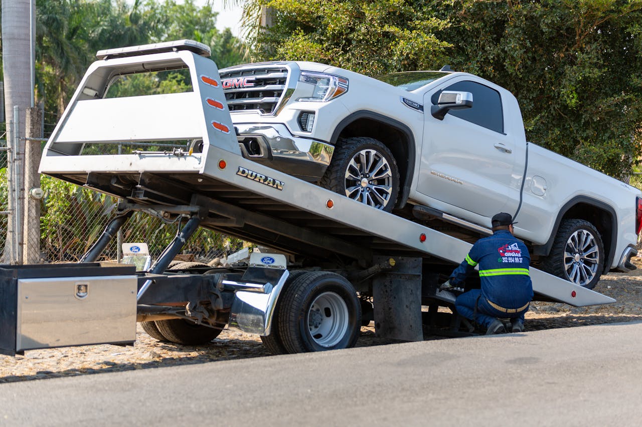Wrecker service loading a truck onto a flatbed in Carlsbad, CA